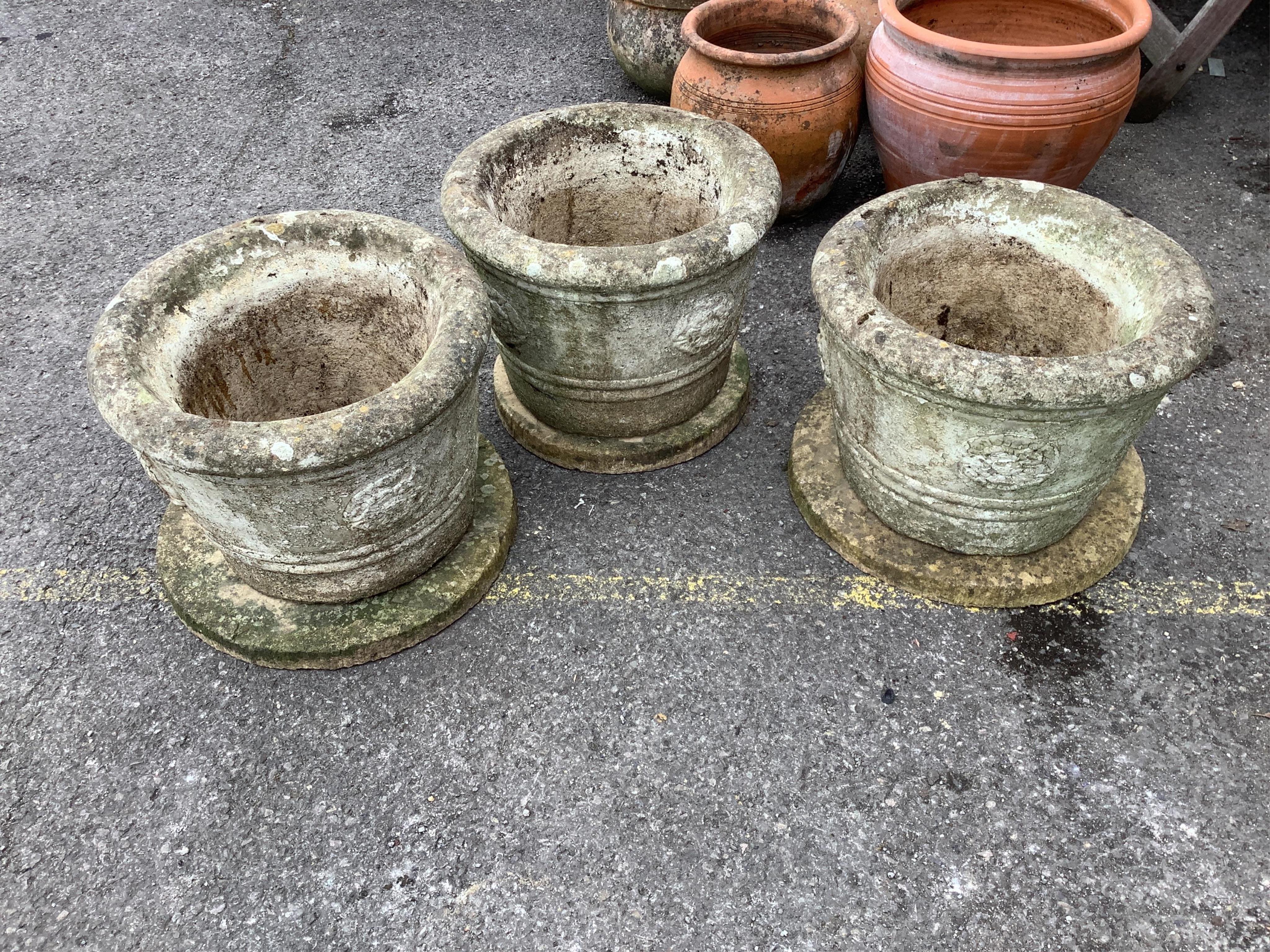 A set of three circular reconstituted stone garden planters with dished bases, diameter 43cm, height 44cm